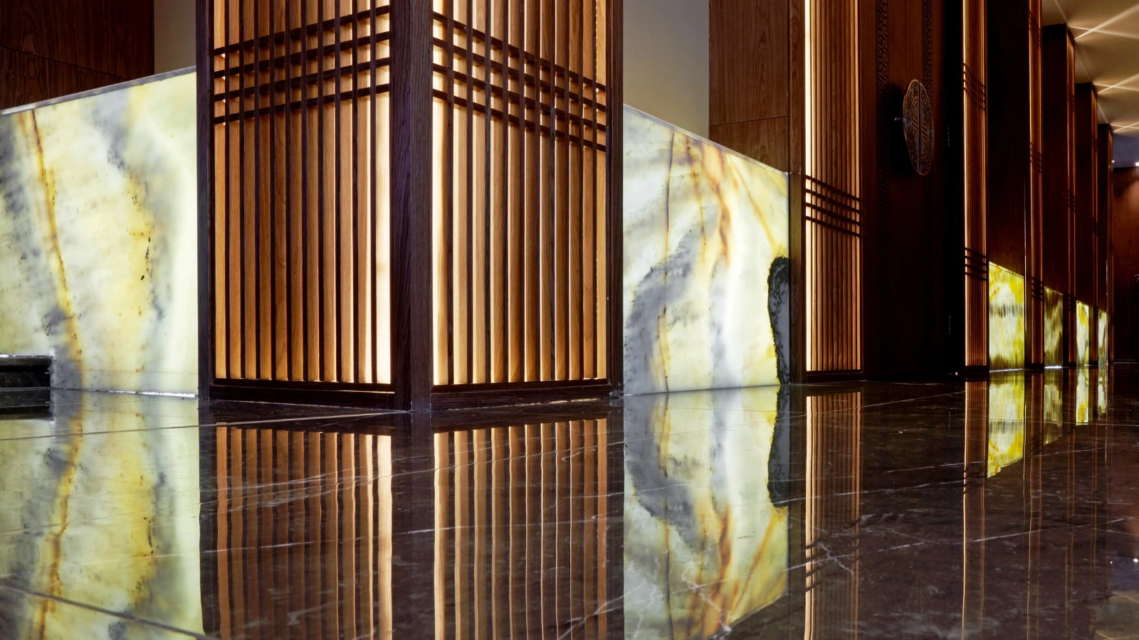 Backlit onyx feature wall glowing in a luxury Dubai interior.